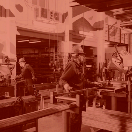 Photo of inside of factory that is greyscale with a red filter.